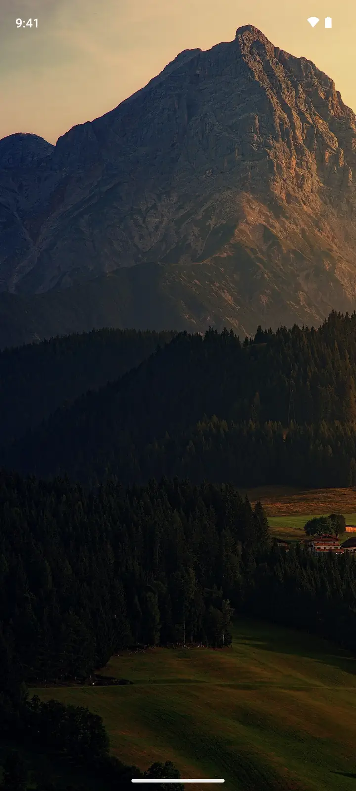 A phone home screen showing the same sunset mountain photo as the live wallpaper
